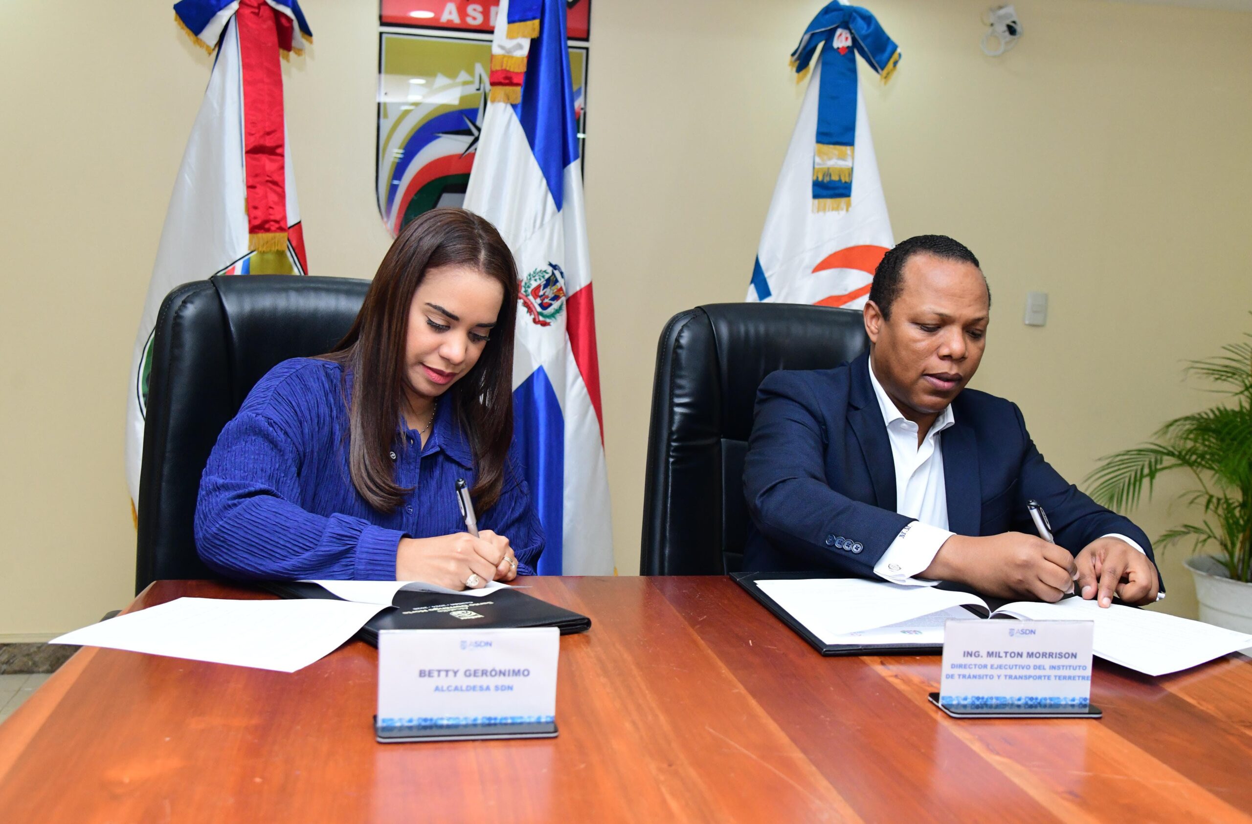 Milton Morrison y Betty Gerónimo firman acuerdo entre el INTRANT y la Alcaldía de Santo Domingo Norte para mejorar el tránsito y la seguridad vial en el municipio.