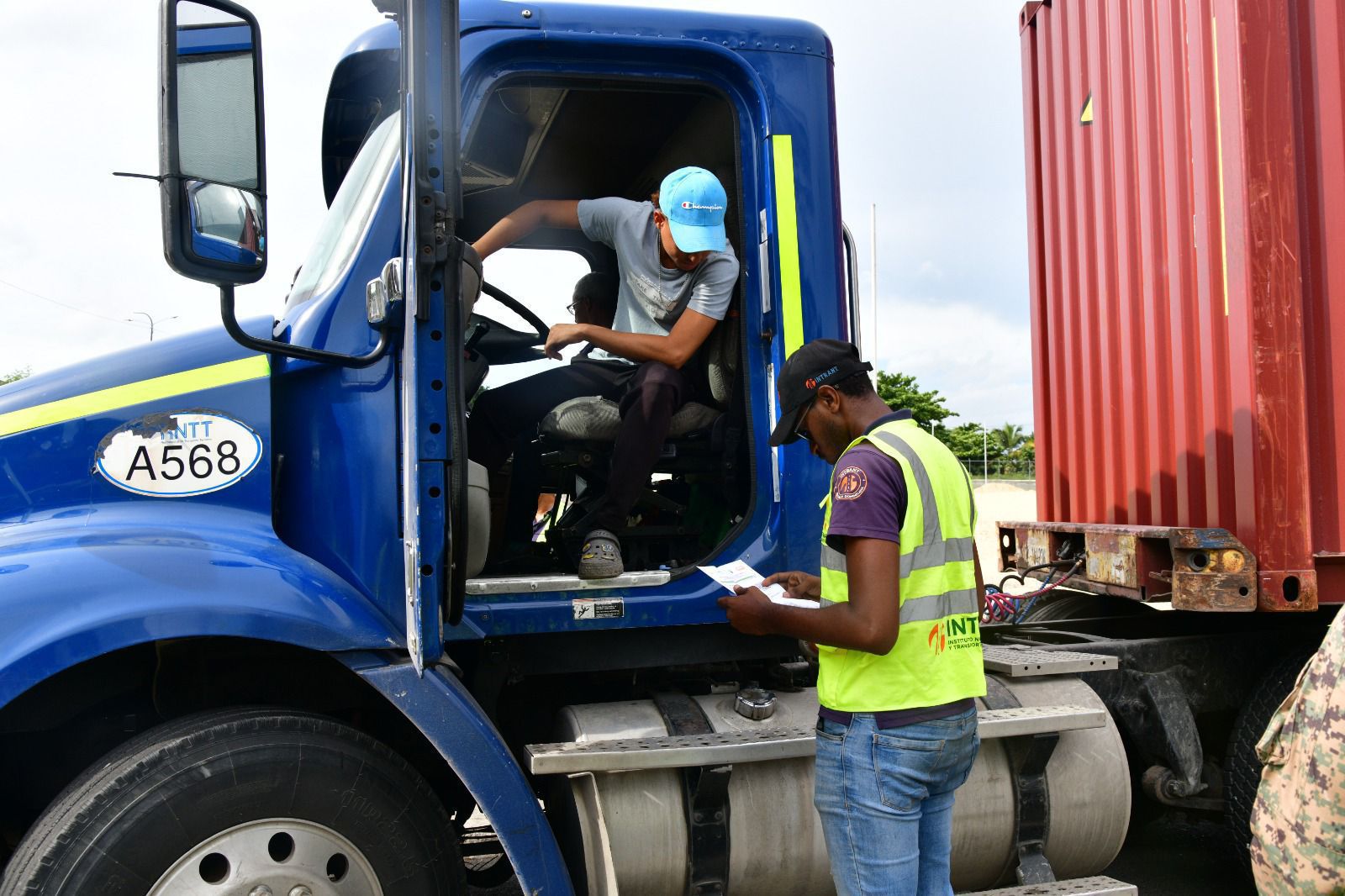 Agente de intrant verificando el permiso digital con código QR del INTRANT a un conductor de carga.